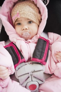 Mixed race baby in car seat sucking pacifier