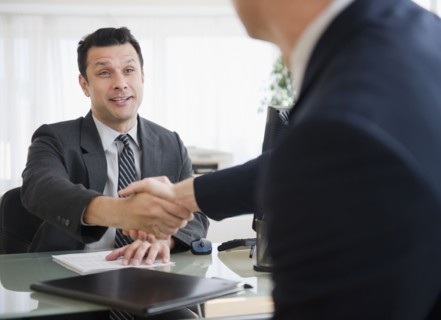 Businessmen shaking hands in office