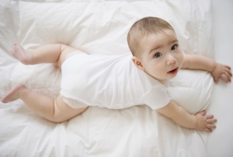 Mixed race baby boy laying on floor