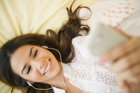 Hispanic woman listening to mp3 player
