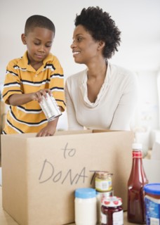 Black mother and son boxing food for donation