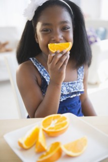 Black girl eating oranges