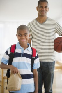 African American boy holding lunch sack