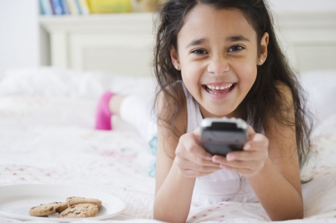 Mixed race girl using remote control