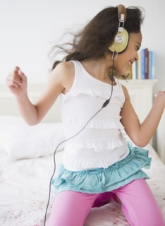 Mixed race girl listening to music on headphones
