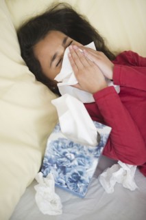 Mixed race girl blowing her nose