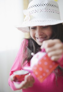 Mixed race girl pouring tea