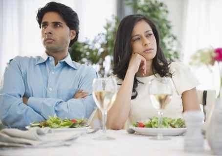 Unhappy mixed race couple dining together