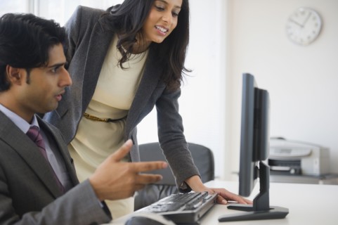 Mixed race business people looking at computer