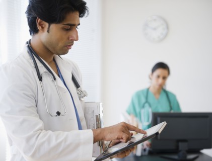 Mixed race doctor using digital tablet