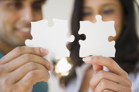 Mixed race couple holding puzzle pieces