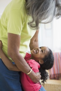 African American grandmother and granddaughter hugging