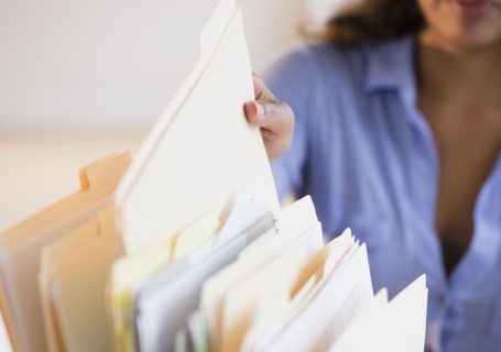 Cape Verdean woman picking up file folder