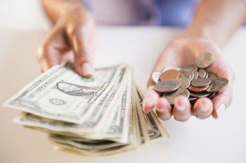 Cape Verdean woman holding dollar bills and coins