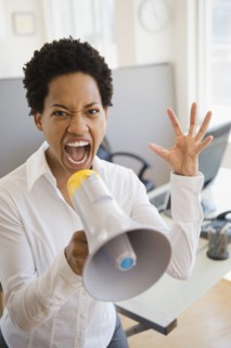 African American businesswoman using bullhorn in office