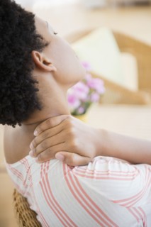 African American woman rubbing sore neck