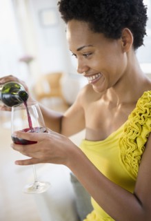 African American woman pouring red wine