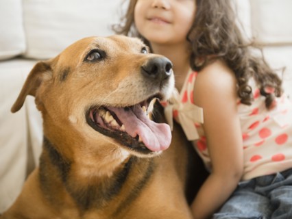 Mixed race girl sitting with dog