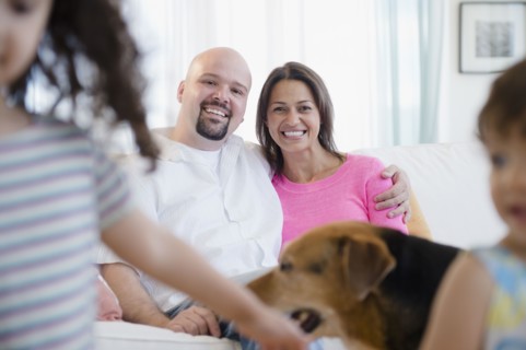 Mother and father watching children and dog