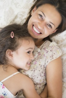 Mother and daughter laying on bed