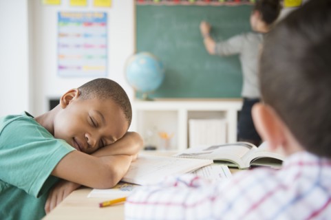 African American boy sleeping in classroom