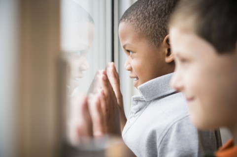 Boys looking out window together