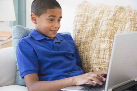 Hispanic boy typing on laptop