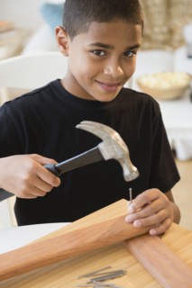 Hispanic boy using hammer and nails