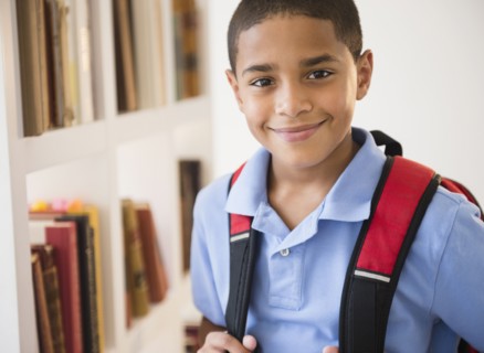 Smiling Hispanic boy carrying backpack