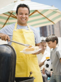 Hispanic father and son at barbecue