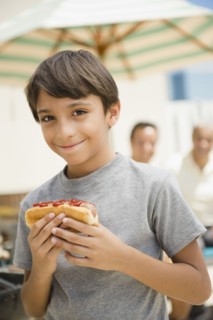 Hispanic boy eating hot dog