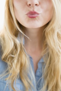 Caucasian woman blowing a kiss