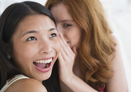 Women whispering to each other