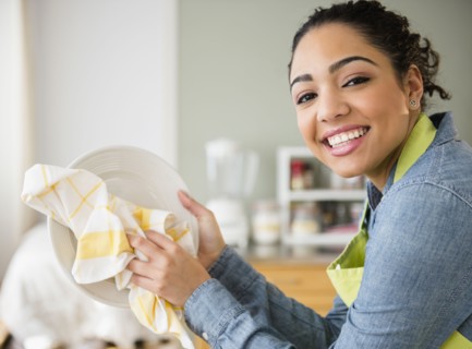 Hispanic woman wiping plate