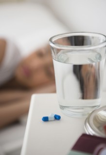 Close up of pills and water on bedside table