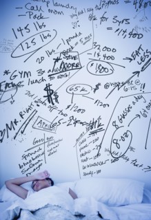 Hispanic woman with scribbled worries over bed