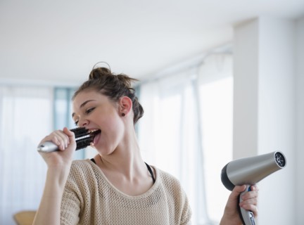 Hispanic girl singing into hairbrush