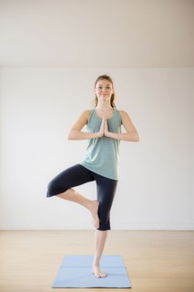 Hispanic girl practicing yoga in studio