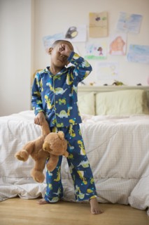 African American boy waking up in bedroom