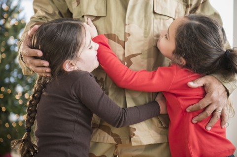 Daughters hugging soldier father