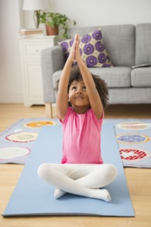 African American girl practicing yoga in living room