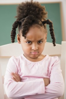 African American girl frowning in classroom