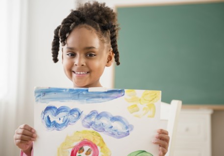 African American girl with painting in classroom