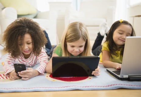 Girls using technology on carpet