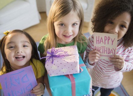 Girls holding presents and cards at birthday party