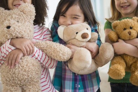 Girls hugging teddy bears
