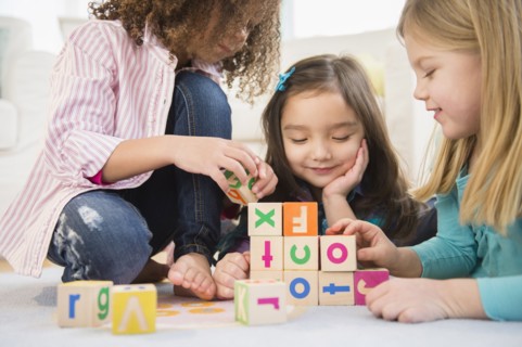 Girls playing with colorful blocks in living room