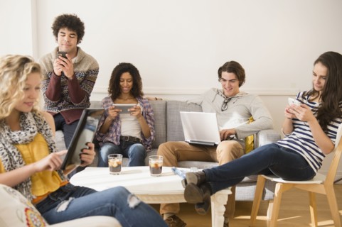 Friends using technology in living room