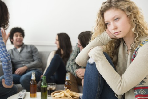 Woman sitting apart from friends