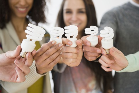 Friends holding fluorescent light bulbs